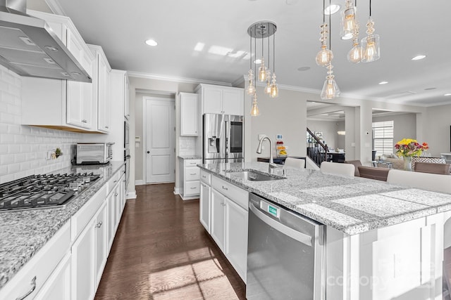 kitchen featuring appliances with stainless steel finishes, white cabinetry, sink, a large island with sink, and wall chimney exhaust hood