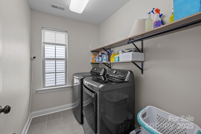 clothes washing area with light tile patterned flooring and independent washer and dryer