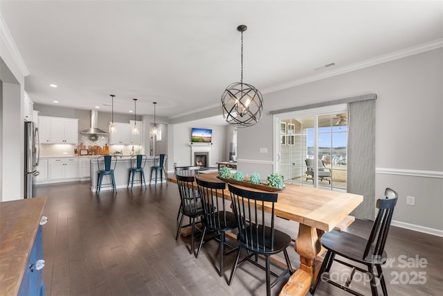 dining area with a warm lit fireplace, visible vents, dark wood-style floors, crown molding, and recessed lighting