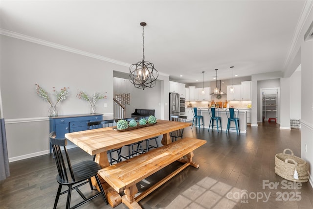 dining space featuring crown molding, dark wood-style flooring, a notable chandelier, and baseboards