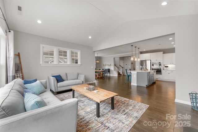 living room featuring lofted ceiling, recessed lighting, dark wood finished floors, and an inviting chandelier