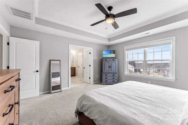 bedroom with a raised ceiling, visible vents, and light colored carpet