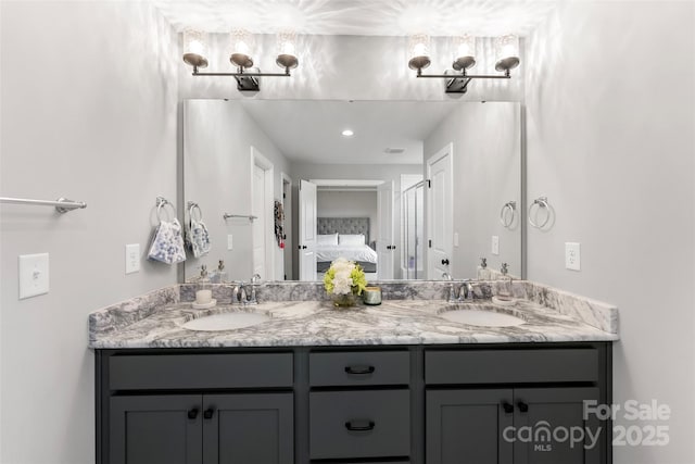 ensuite bathroom with double vanity, a sink, and connected bathroom