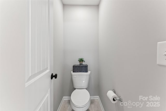 bathroom with toilet and baseboards