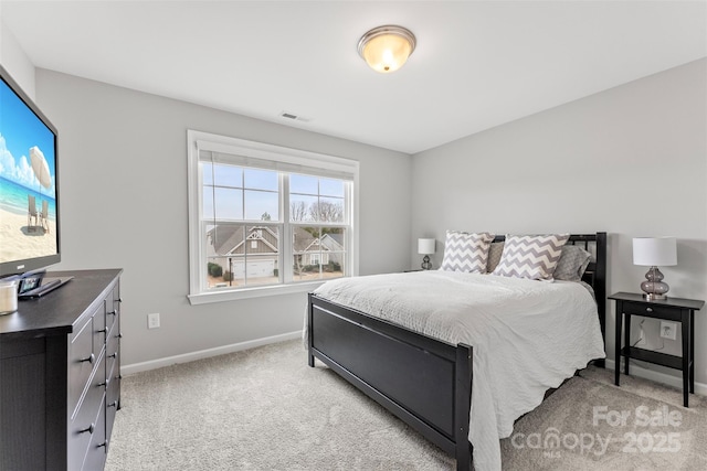 bedroom featuring baseboards, visible vents, and light colored carpet