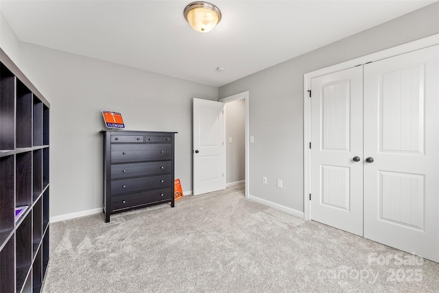 unfurnished bedroom featuring light carpet, baseboards, and a closet