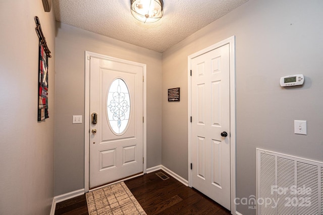 entrance foyer featuring dark hardwood / wood-style flooring and a textured ceiling