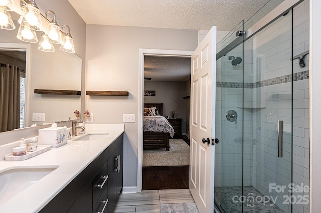 bathroom featuring vanity, a notable chandelier, a textured ceiling, and walk in shower