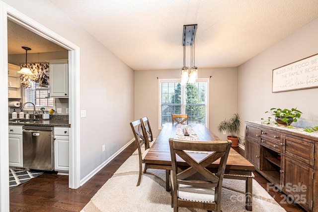 dining room with dark hardwood / wood-style floors, sink, and a textured ceiling