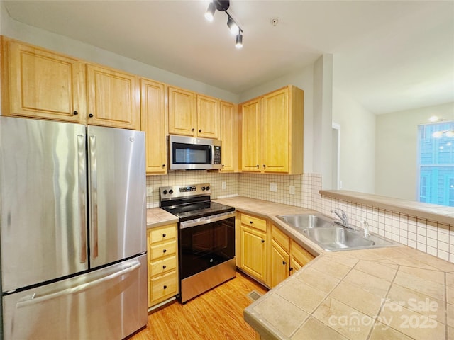 kitchen with light brown cabinetry, sink, tile countertops, and stainless steel appliances