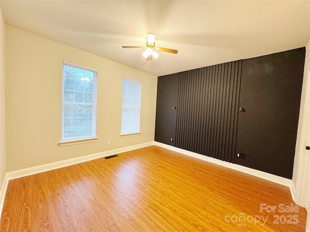 empty room with wood-type flooring and ceiling fan