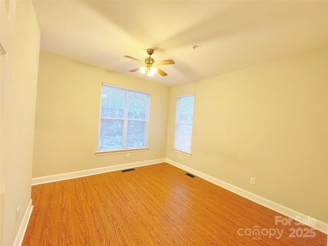 spare room with ceiling fan and light wood-type flooring