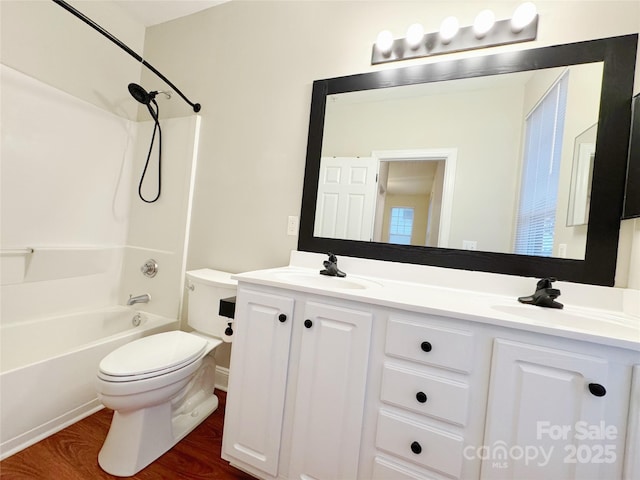 full bathroom featuring vanity, hardwood / wood-style flooring, toilet, and washtub / shower combination