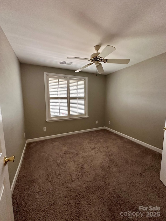 empty room featuring dark carpet, a textured ceiling, and ceiling fan