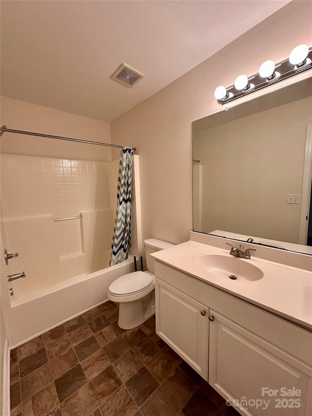 full bathroom with vanity, shower / tub combo, and toilet