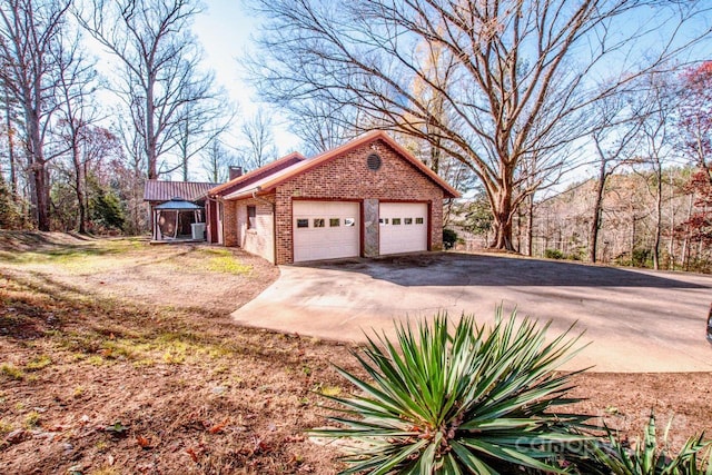 view of side of property with a garage and a gazebo