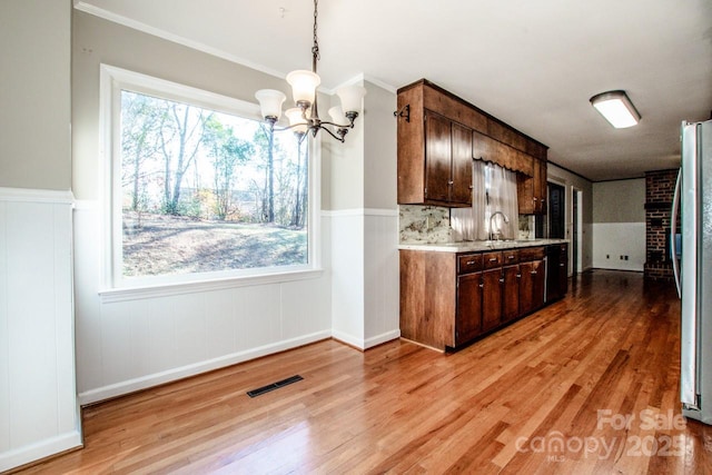 kitchen featuring sink, stainless steel fridge, a chandelier, dark brown cabinets, and light hardwood / wood-style flooring