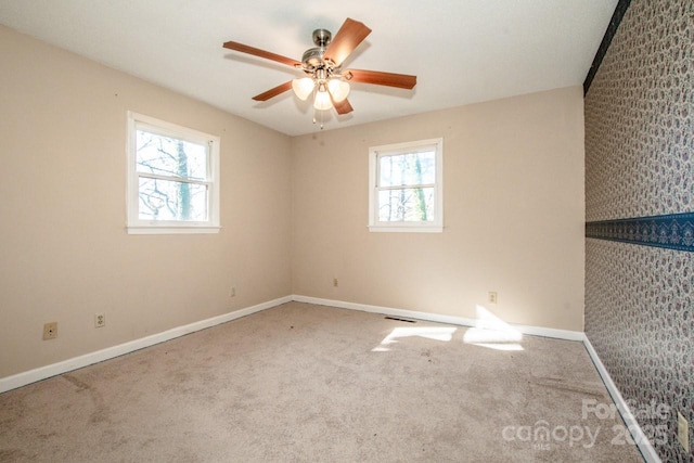 carpeted empty room with plenty of natural light and ceiling fan