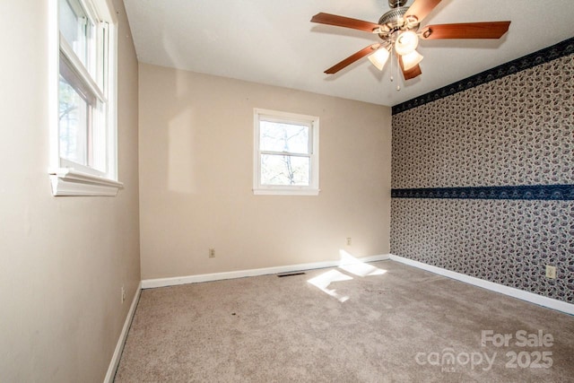 carpeted spare room featuring ceiling fan