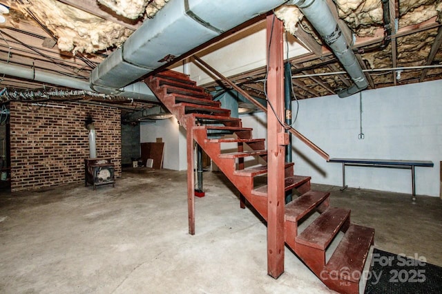 basement with brick wall and a wood stove