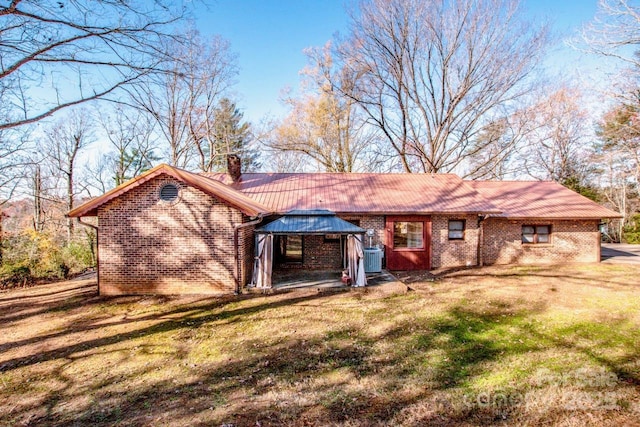 rear view of house featuring a gazebo, central AC unit, and a lawn