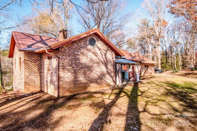 view of side of home featuring a lawn and central air condition unit