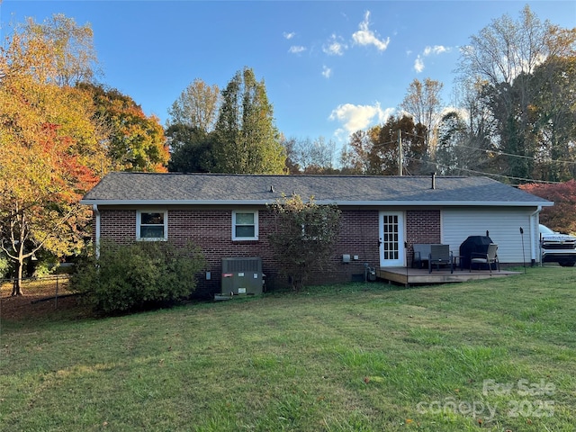 rear view of house featuring cooling unit and a yard