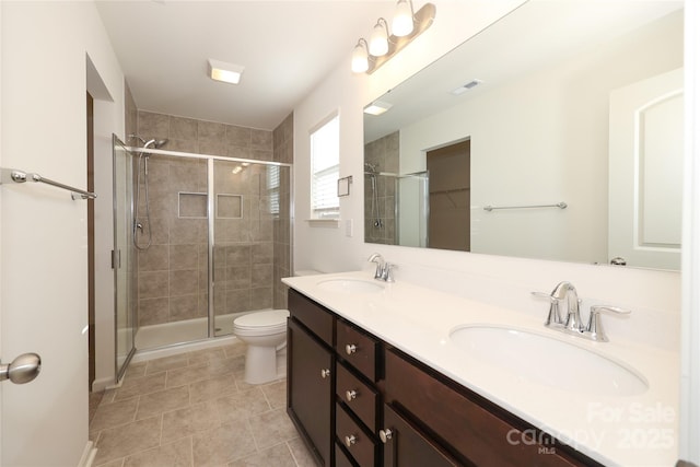 bathroom with vanity, toilet, tile patterned flooring, and a shower with door