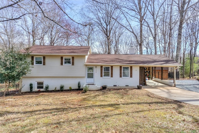 tri-level home featuring a front lawn and a carport