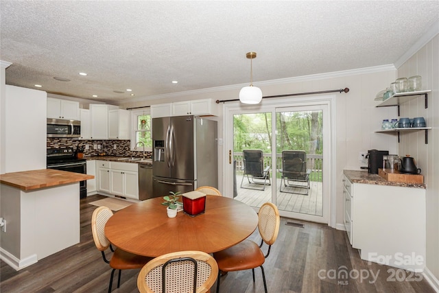 dining area featuring crown molding, dark wood-style floors, and a textured ceiling