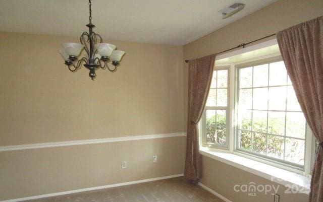 empty room featuring a notable chandelier