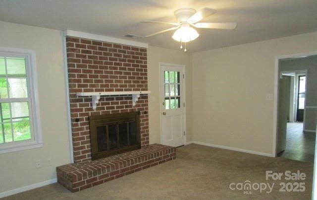 unfurnished living room with ceiling fan, a fireplace, and carpet floors