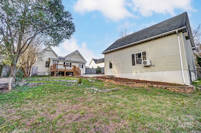 rear view of property featuring a yard, fence, and a wooden deck