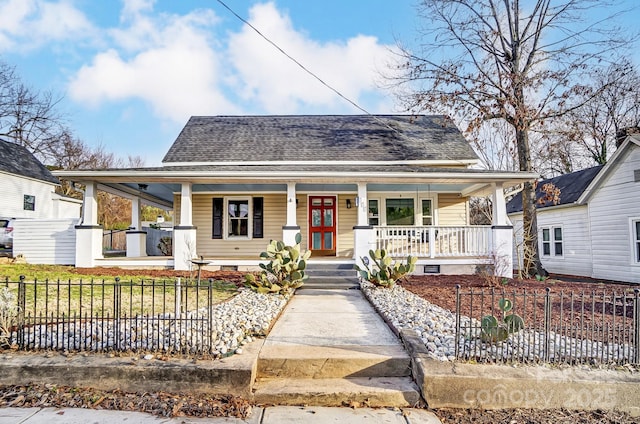 view of front of property with crawl space, covered porch, a fenced front yard, and roof with shingles