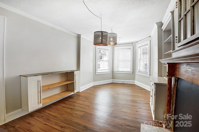 interior space featuring a textured ceiling, ornamental molding, and dark wood-style flooring