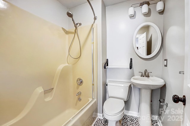 bathroom with toilet, washtub / shower combination, baseboards, and a sink