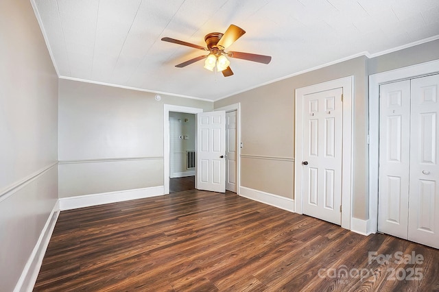 unfurnished bedroom with crown molding, dark wood-style flooring, visible vents, and baseboards