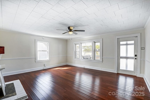 unfurnished living room with dark wood-style floors, ornamental molding, and a wealth of natural light