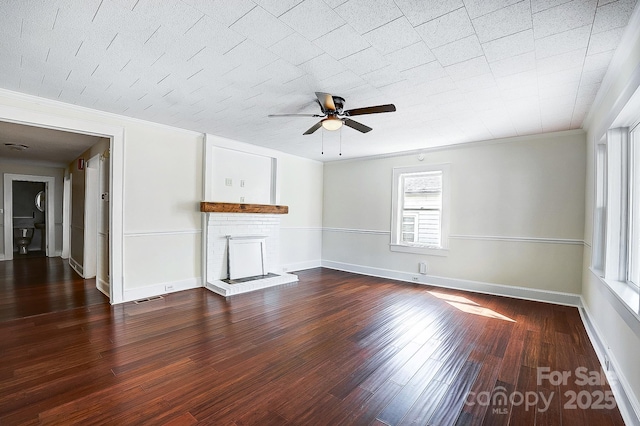 unfurnished living room featuring baseboards, a ceiling fan, dark wood-style flooring, crown molding, and a brick fireplace