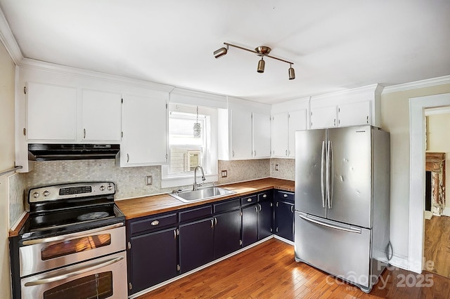 kitchen with blue cabinets, under cabinet range hood, stainless steel appliances, a sink, and white cabinets