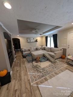 living room featuring hardwood / wood-style floors and a tray ceiling