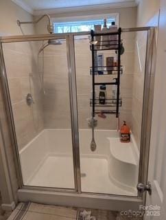 bathroom with crown molding, radiator, and a shower with shower door