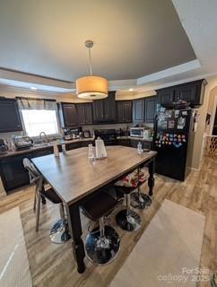 dining room featuring a tray ceiling, light hardwood / wood-style flooring, and ornamental molding