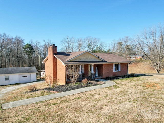 single story home with a garage, an outdoor structure, and a front lawn