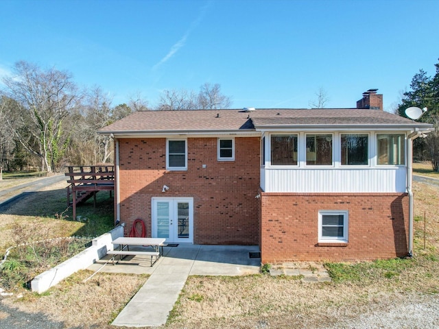 back of house featuring french doors, a patio, and a lawn