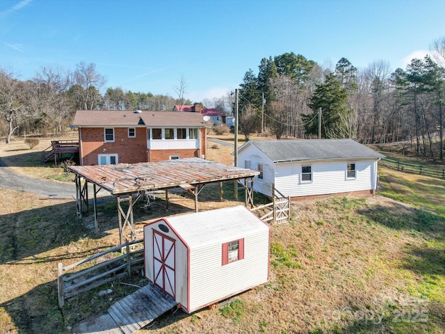 rear view of property with a shed and a lawn