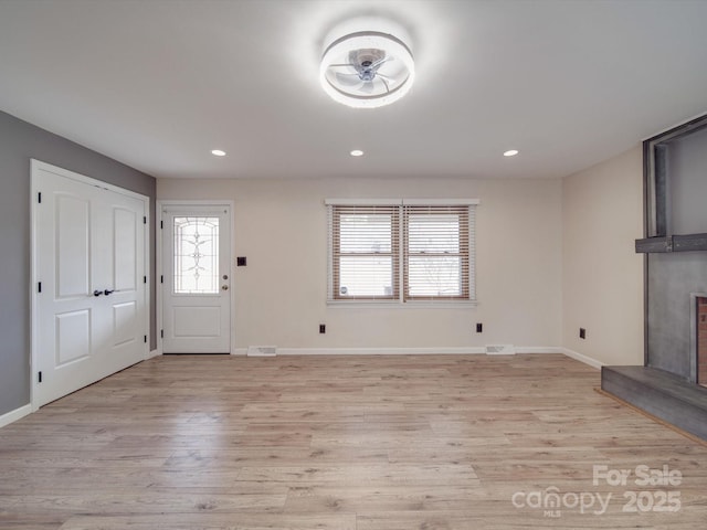 foyer featuring a large fireplace and light wood-type flooring