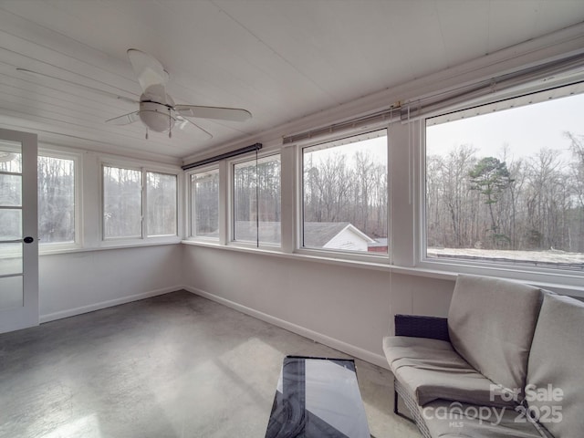 unfurnished sunroom featuring ceiling fan