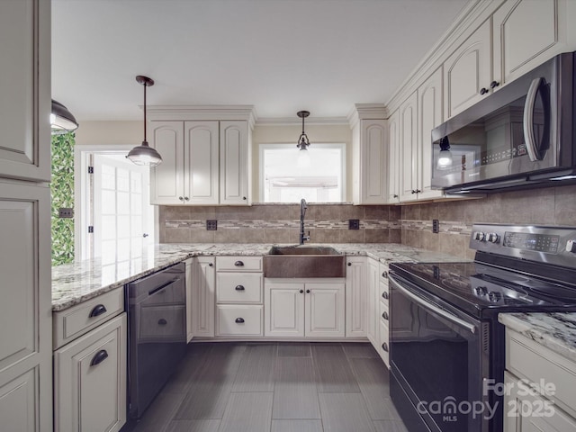 kitchen featuring appliances with stainless steel finishes, decorative light fixtures, sink, and white cabinets