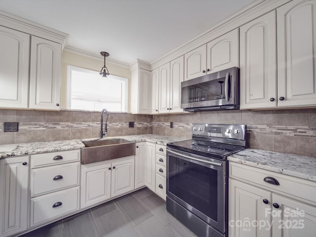 kitchen with sink, white cabinetry, decorative light fixtures, appliances with stainless steel finishes, and backsplash